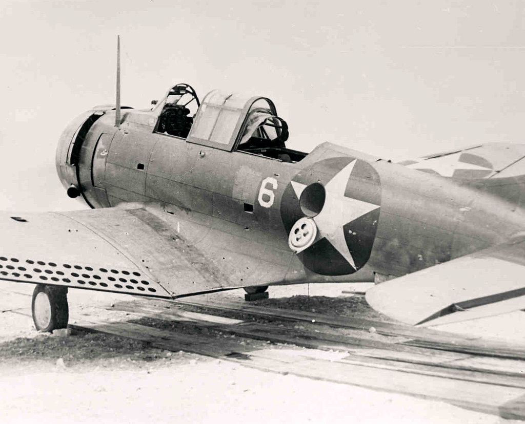 "View of the port side of Douglas SBD-2 Dauntless (BuNo 2106) showing battle damage inflicted during the Battle of Midway. This photograph was taken on the Midway Atoll." by aeroman3 is marked with CC0 1.0